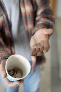 Hands of Homeless Man with Change in Cup